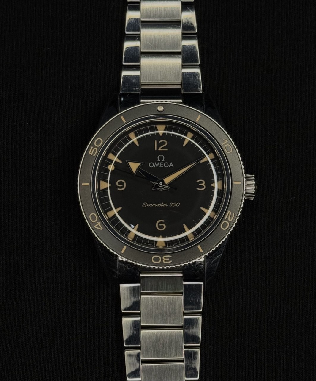 Rolex Submariner completo en flat lay sobre pared Santorini