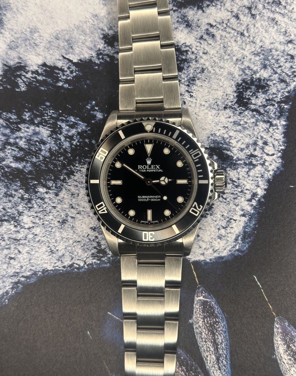 Omega Seamaster completo en flat lay sobre pared Santorini