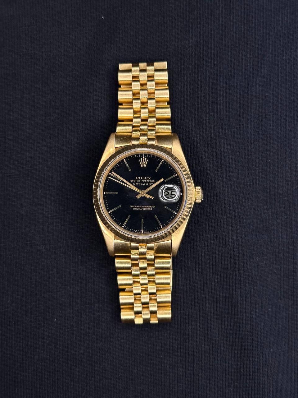 Rolex Submariner completo en flat lay sobre pared Santorini